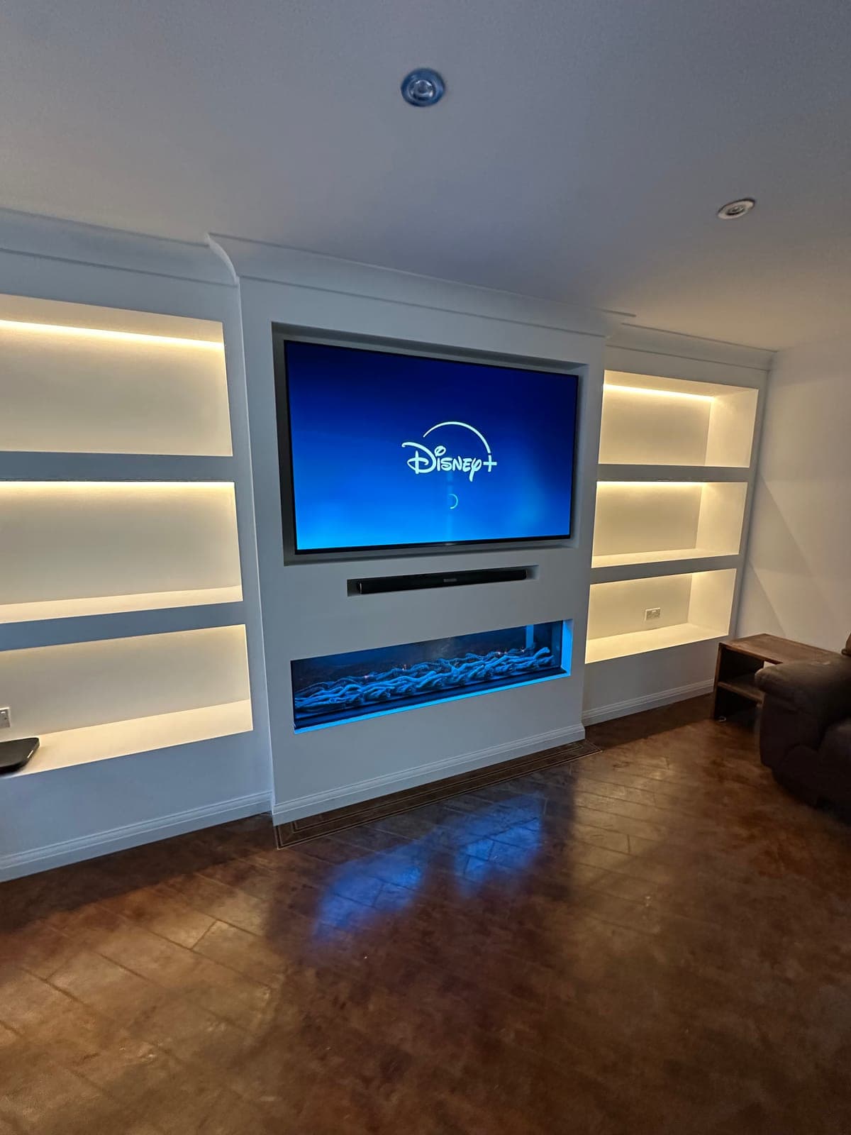 Media Wall Installation — Media wall with backlit alcove shelving, recessed soundbar and electric fire.