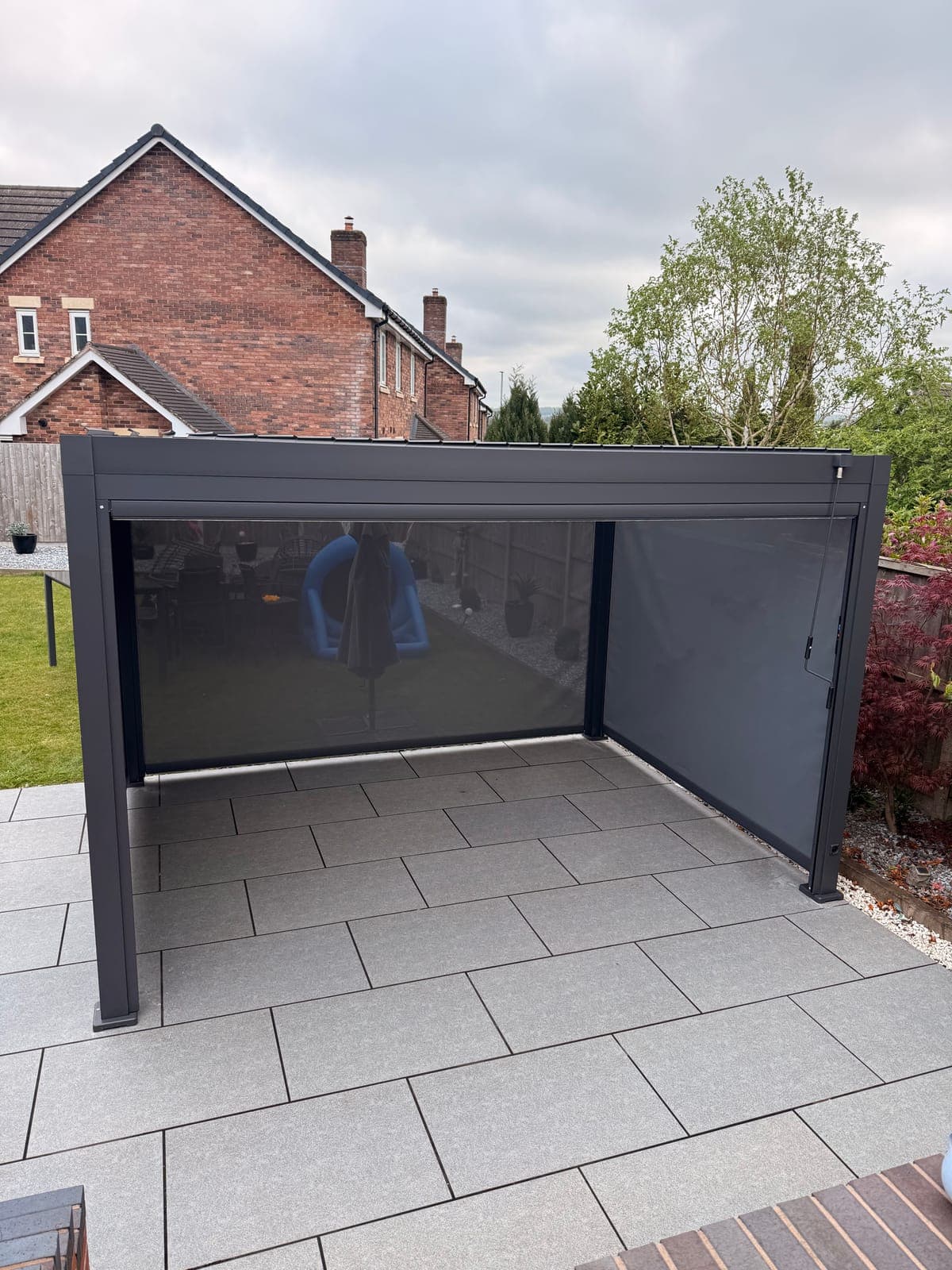 Aluminium Louvered Pergola — Aluminium louvered pergola with a closed roof over a porcelain patio.